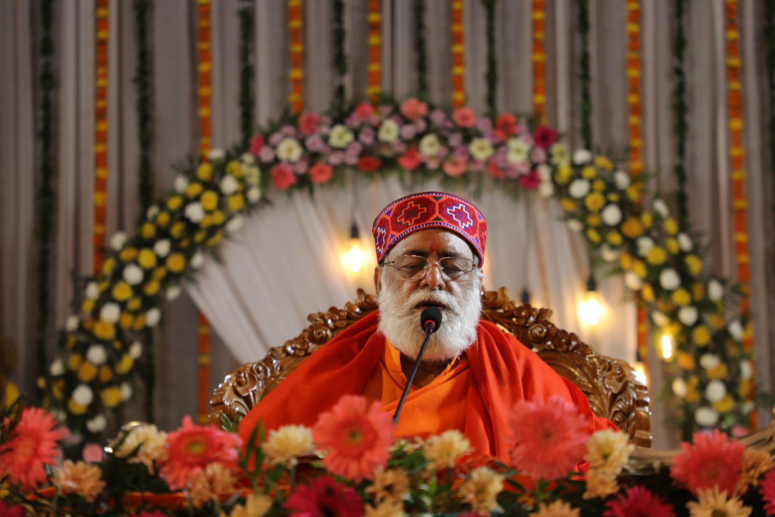 Gurudev Ji discoursing amid flowers